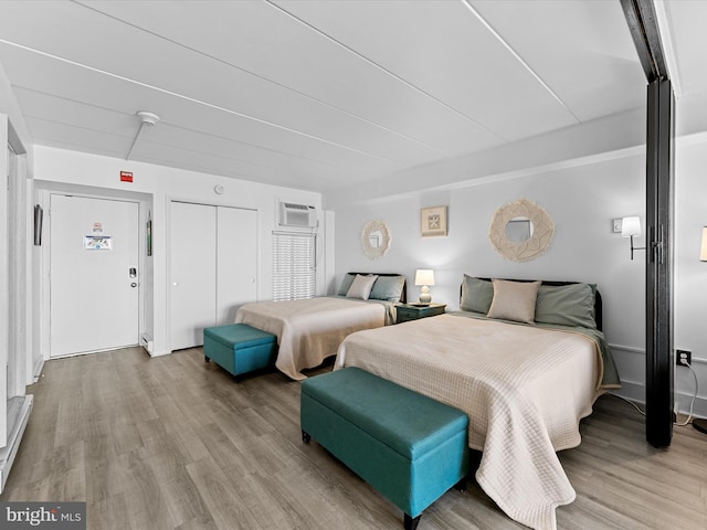 bedroom featuring a wall mounted air conditioner and hardwood / wood-style floors