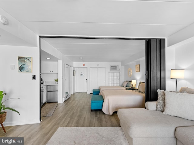 living room featuring light hardwood / wood-style floors and an AC wall unit