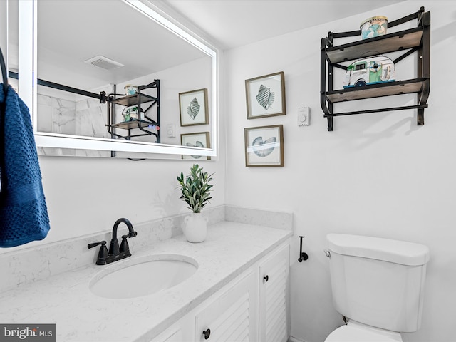 bathroom featuring vanity, a shower, and toilet