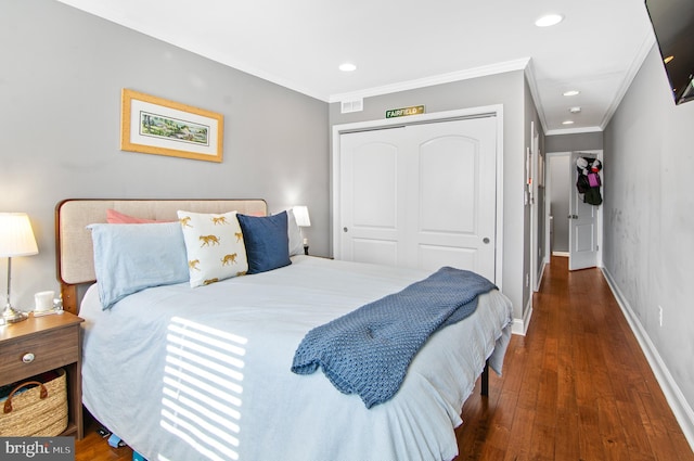 bedroom with a closet, crown molding, and dark hardwood / wood-style flooring