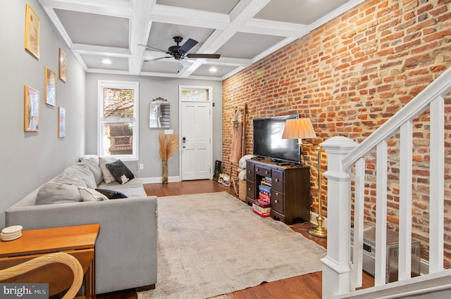 living room with ceiling fan, brick wall, light hardwood / wood-style flooring, beamed ceiling, and coffered ceiling