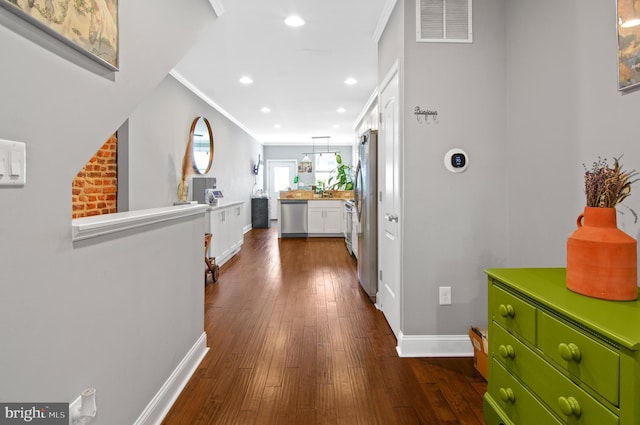 corridor featuring ornamental molding and dark hardwood / wood-style flooring