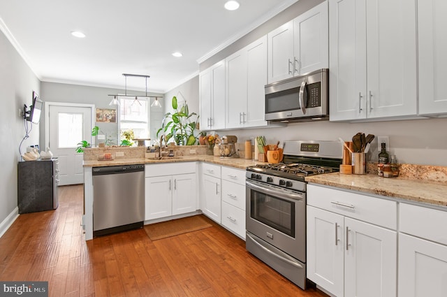 kitchen featuring white cabinets, kitchen peninsula, stainless steel appliances, and light hardwood / wood-style floors