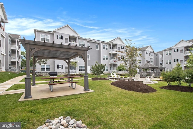 view of property's community with a pergola, a gazebo, and a lawn