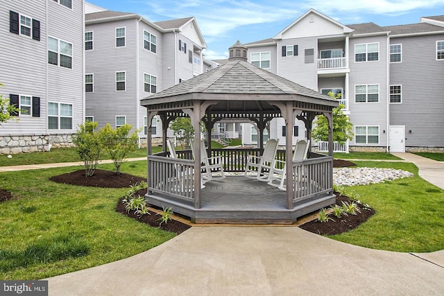 view of community featuring a gazebo, a deck, and a lawn