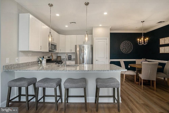 kitchen featuring appliances with stainless steel finishes, white cabinets, sink, and ornamental molding