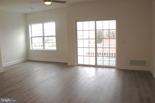 unfurnished room featuring dark wood-type flooring and ceiling fan