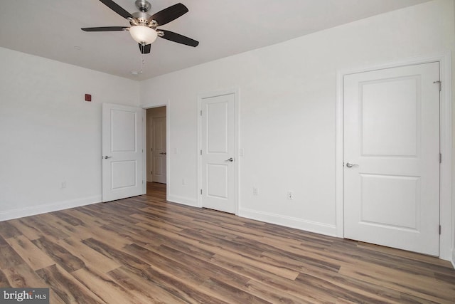 unfurnished bedroom with dark wood-type flooring and ceiling fan