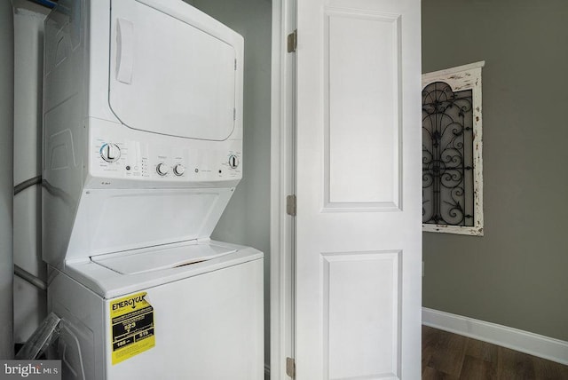 clothes washing area featuring stacked washing maching and dryer and dark hardwood / wood-style floors