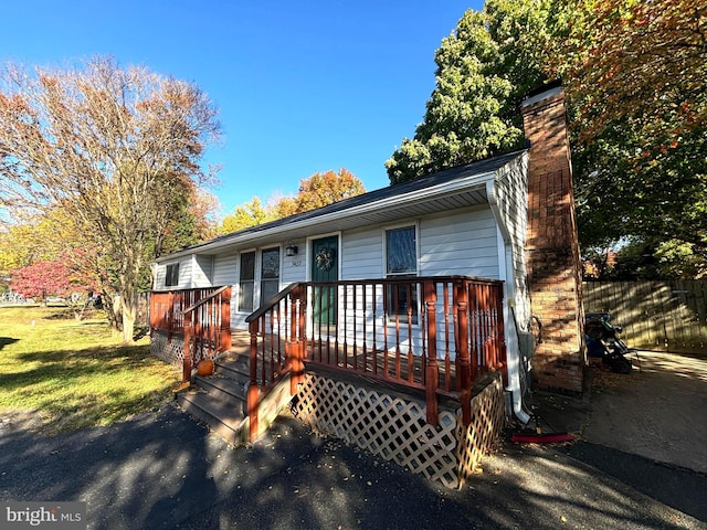 view of front of property featuring a front yard and a wooden deck