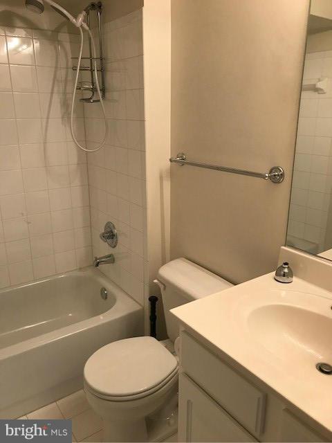 full bathroom featuring vanity, toilet, tile patterned flooring, and tiled shower / bath