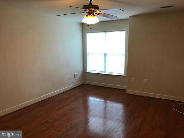 unfurnished room with dark wood-type flooring and ceiling fan