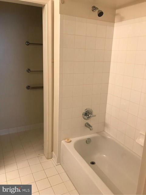 bathroom featuring tile patterned flooring and tiled shower / bath