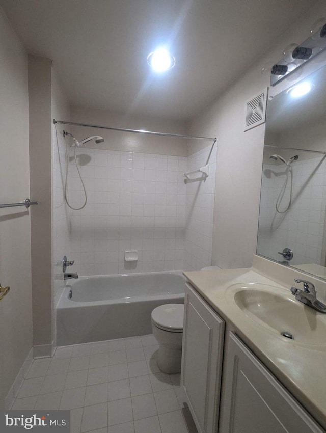 full bathroom with vanity, tiled shower / bath combo, toilet, and tile patterned floors