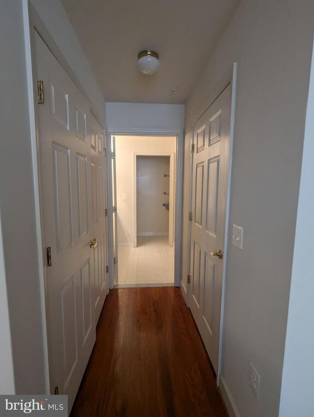 hallway with dark hardwood / wood-style flooring