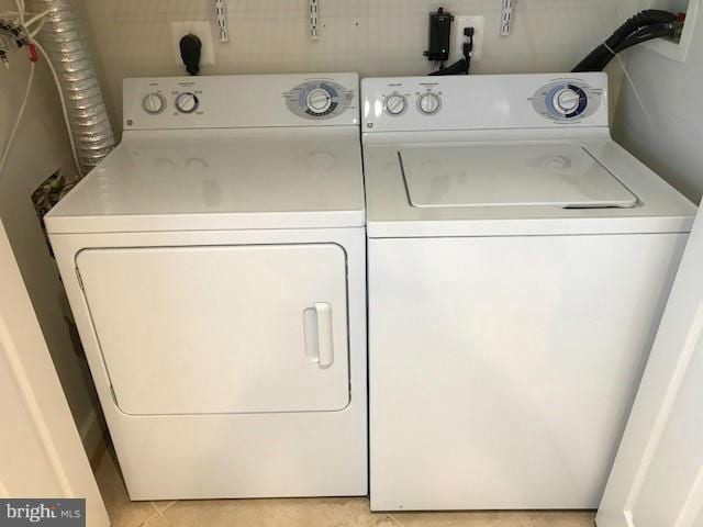 washroom featuring washing machine and clothes dryer and light tile patterned floors