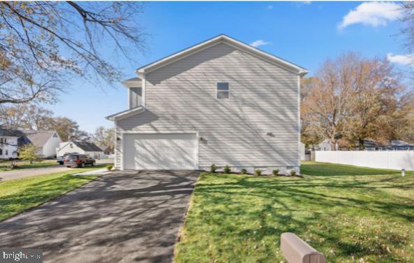 view of side of property with a yard and a garage