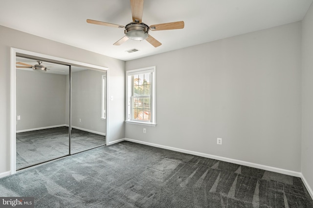 unfurnished bedroom with a closet, dark colored carpet, and ceiling fan