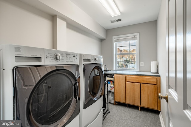 washroom featuring cabinets and washing machine and dryer