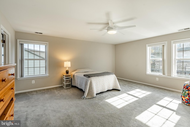 carpeted bedroom with multiple windows and ceiling fan