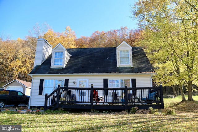 cape cod home featuring a wooden deck and a front lawn