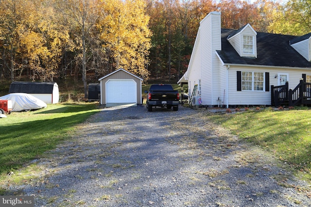 view of front of home with a storage unit, a front lawn, and a garage