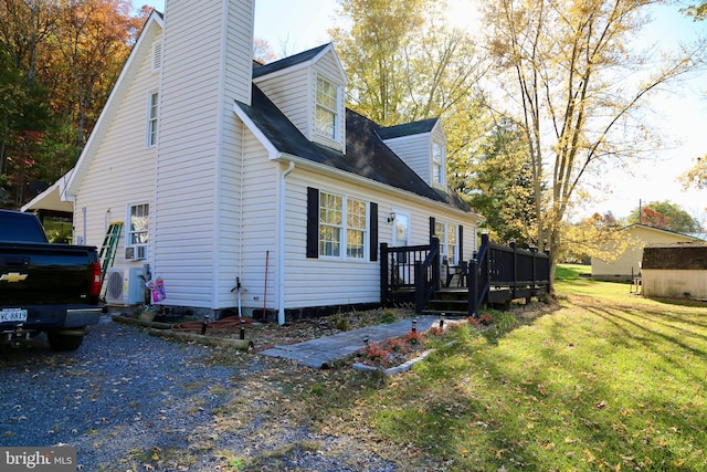 view of side of home with a deck and a yard