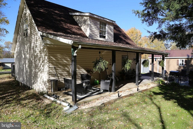 rear view of property featuring a yard and a patio