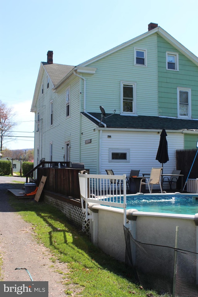 back of house with a swimming pool side deck