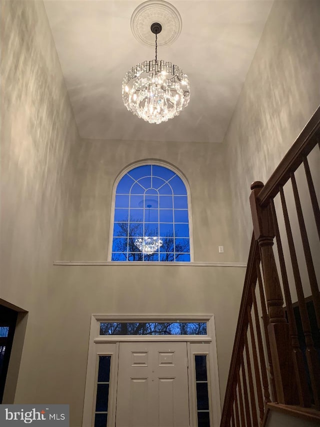 foyer with a towering ceiling and a notable chandelier