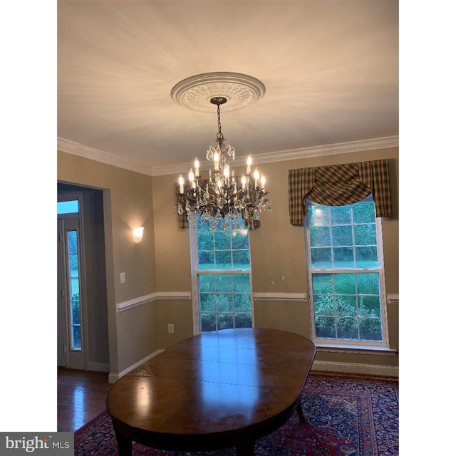 unfurnished dining area featuring crown molding, a chandelier, and wood-type flooring