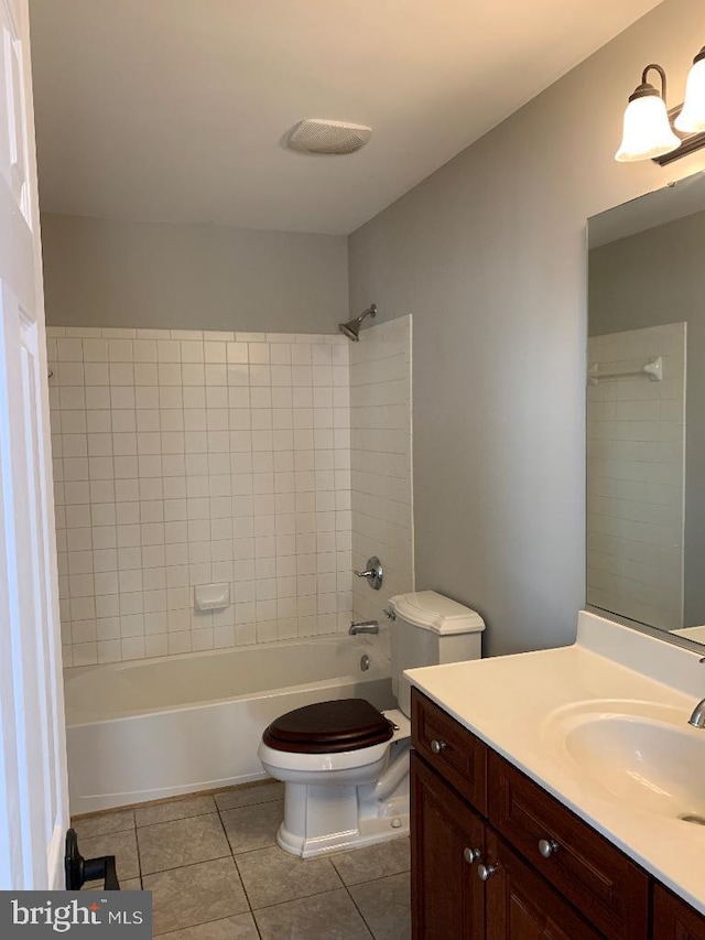 full bathroom with toilet, tiled shower / bath combo, vanity, and tile patterned flooring