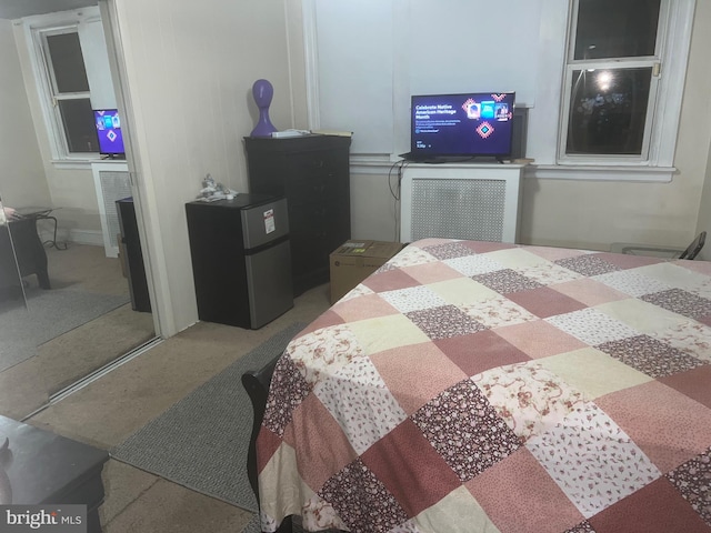 bedroom with refrigerator, carpet flooring, and a closet