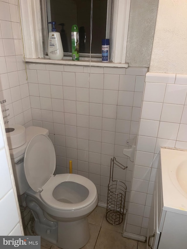 bathroom featuring vanity, tile patterned flooring, toilet, and tile walls