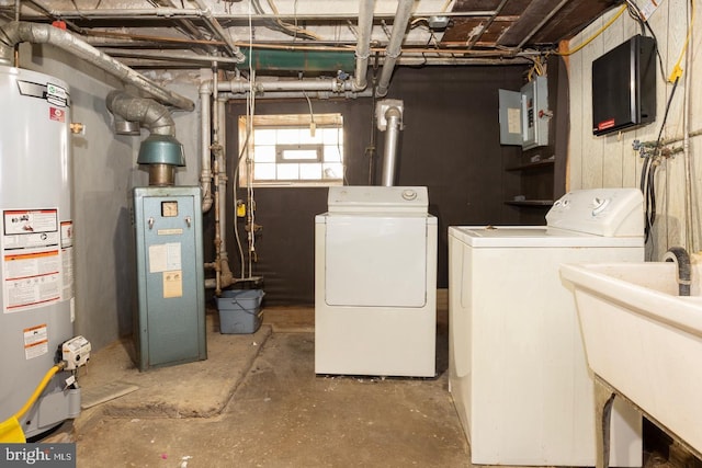 laundry area with electric panel, washer and dryer, gas water heater, and sink