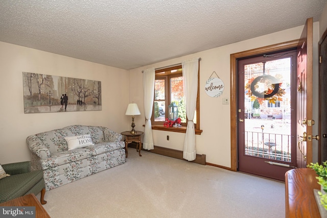 sitting room with a textured ceiling and light colored carpet