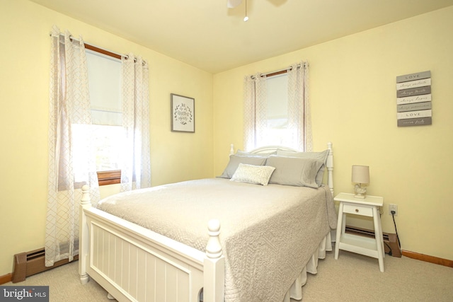 bedroom with light colored carpet and a baseboard radiator