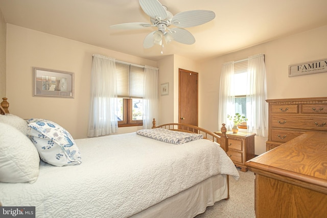 bedroom with ceiling fan, multiple windows, and light colored carpet