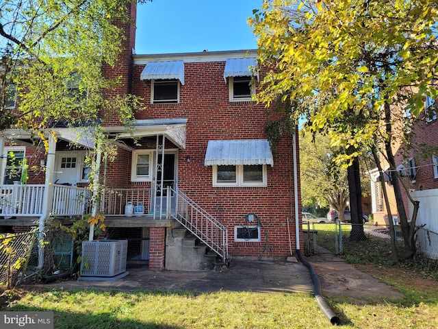 back of house with central AC unit