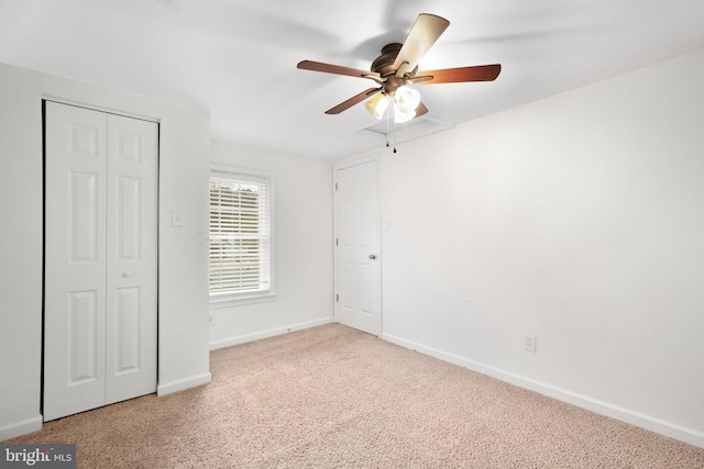 unfurnished bedroom featuring light carpet, a closet, and ceiling fan