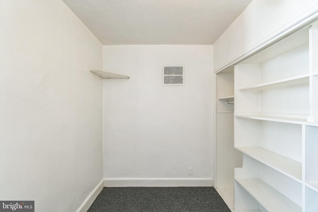 spacious closet featuring dark carpet