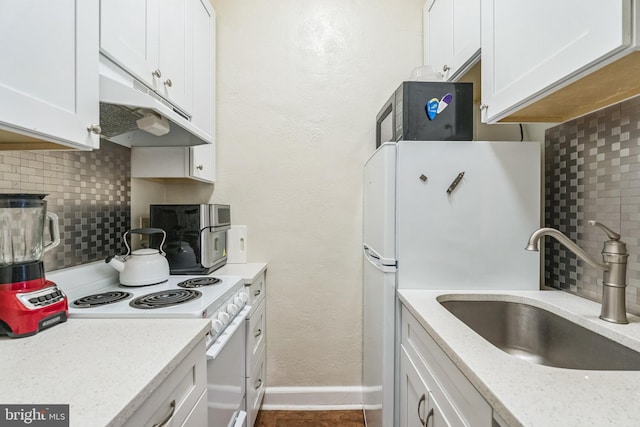 kitchen with white cabinetry, decorative backsplash, light stone countertops, and sink