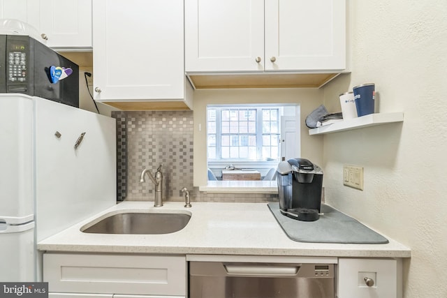 kitchen with white cabinets, backsplash, dishwasher, white fridge, and sink