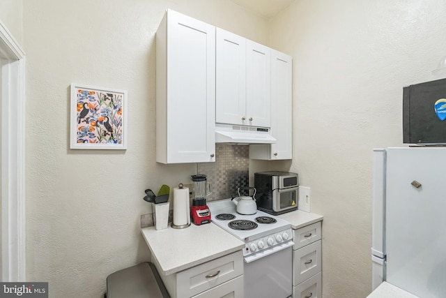 kitchen featuring white appliances, tasteful backsplash, and white cabinetry