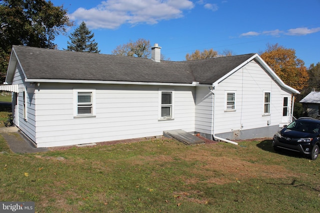 rear view of property with a lawn