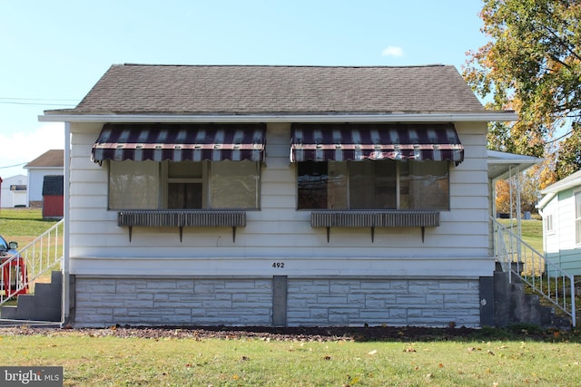 rear view of house featuring a yard