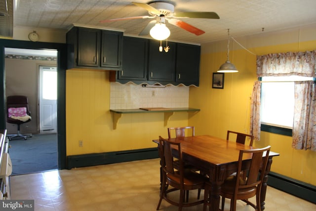 dining area featuring a baseboard heating unit and ceiling fan