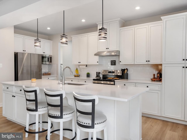 kitchen with white cabinets, sink, an island with sink, and stainless steel appliances