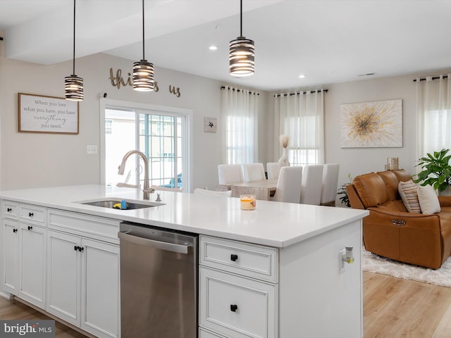 kitchen featuring light hardwood / wood-style floors, stainless steel dishwasher, hanging light fixtures, and sink