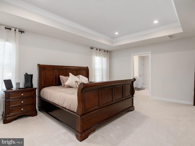 bedroom with light carpet and a tray ceiling